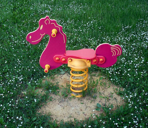 Bild 6: rosa Wipppferd mit gelber Stahlfeder auf einem Rasen